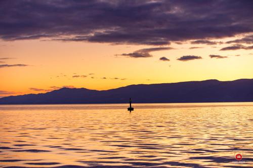 a pole in the middle of the water at sunset at Deluxe Ploech in Rijeka
