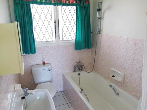 a bathroom with a toilet and a tub and a sink at Claridges 302 in Margate