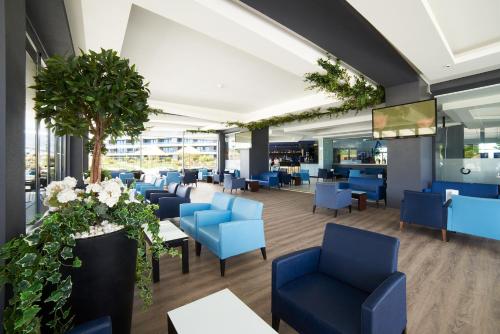 a waiting room with blue chairs and tables at RR Alvor Baía Resort in Alvor