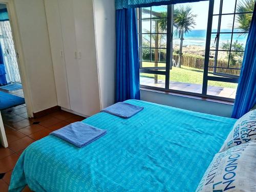 1 dormitorio con cama con sábanas azules y ventana en Southern Comfort - Starfish, en Margate