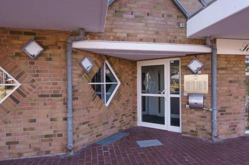 a brick building with a white door and a window at Das Meer Genie En in Scharbeutz