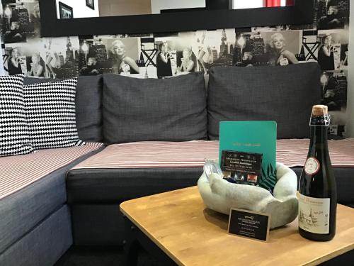 - une bouteille de vin sur une table à côté d'un lit dans l'établissement Appartement Cinéma vidéo-projecteur et garage, à Honfleur