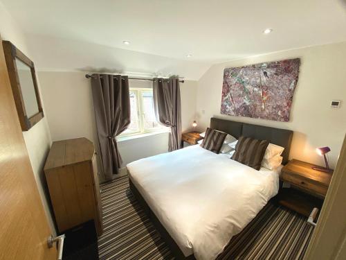 a bedroom with a bed and a painting on the wall at Railway Apartments in Nailsworth