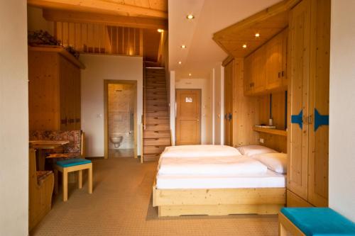 a bedroom with two beds and a staircase at Gasthof Teiser Stern in Funes