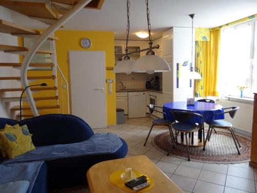 ein Wohnzimmer mit einem blauen Sofa und einem Tisch in der Unterkunft 50076... in Carolinensiel