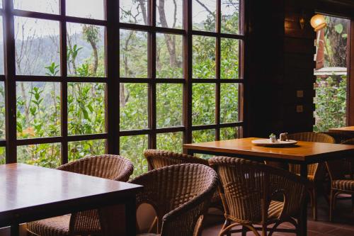 a restaurant with tables and chairs and a large window at Futen Villa in Sanyi
