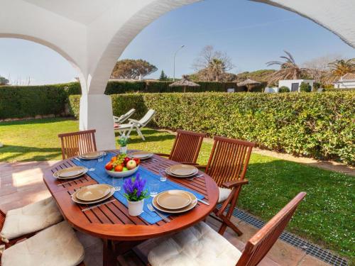 a wooden table with a bowl of fruit on a patio at Holiday Home Ducados Golf by Interhome in Pals
