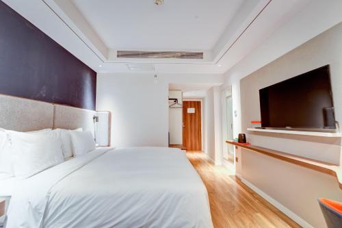 a bedroom with a large bed and a flat screen tv at Holiday Inn Express Xi'an Bell Tower by IHG in Xi'an