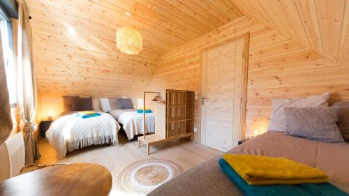 a bedroom with two beds in a wooden cabin at Le Chalet de Juliette in Besse-et-Saint-Anastaise