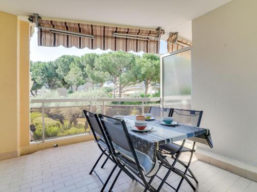 een eetkamer met een tafel en stoelen en een groot raam bij Apartment Le Provence by Interhome in Vallauris