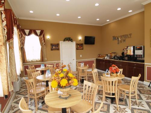 a restaurant with tables and chairs with flowers on them at Parkway Inn Philadelphia Airport in Springfield