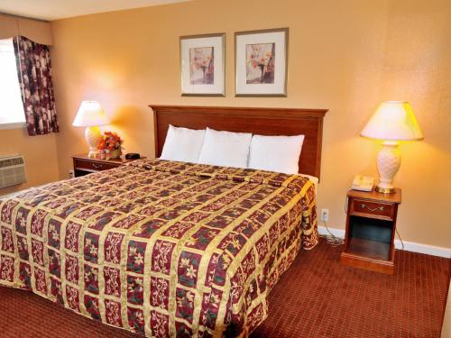 a hotel room with a bed and two lamps at Parkway Inn Philadelphia Airport in Springfield
