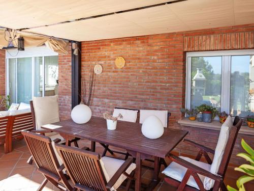 a wooden table and chairs on a patio at Holiday Home Lumiere by Interhome in Sant Antoni de Calonge