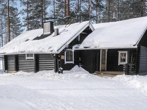 uma cabana de madeira com um telhado coberto de neve em Holiday Home Tavintupa by Interhome em Pertunmaa