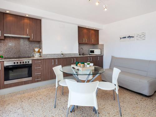 a kitchen with a table and chairs and a couch at Apartment Blue Ocean-3 by Interhome in Llança