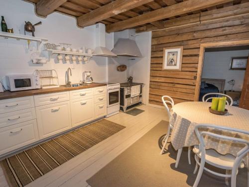 a kitchen with white cabinets and a table with chairs at Holiday Home Nybyggningen by Interhome in Björkboda