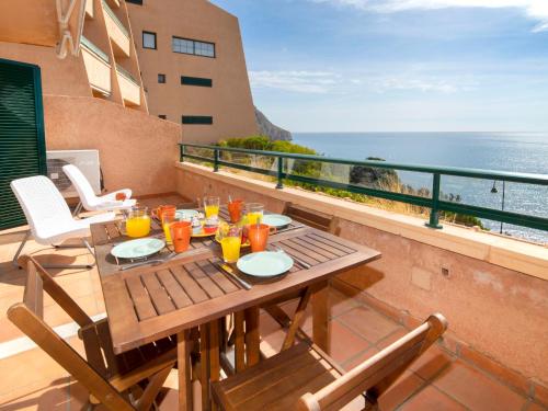 a table on a balcony with a view of the ocean at Apartment Pueblo Mascarat-2 by Interhome in Altea