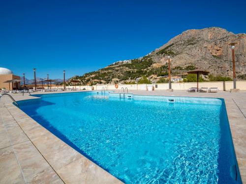 a swimming pool with a mountain in the background at Apartment Pueblo Mascarat-2 by Interhome in Altea