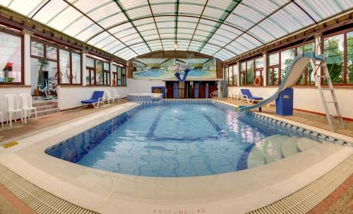 a swimming pool with a slide in a building at Hotel Spa Villa Lina in Villa de Leyva