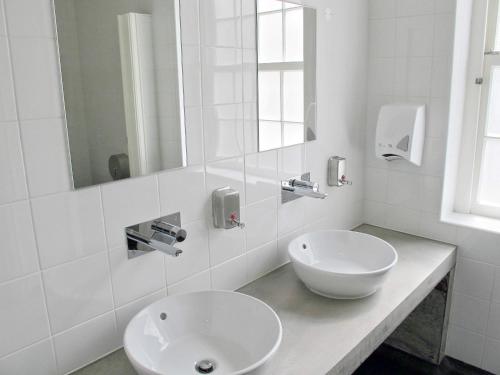a white bathroom with a sink and a mirror at Azores Youth Hostels - Sao Miguel in Ponta Delgada
