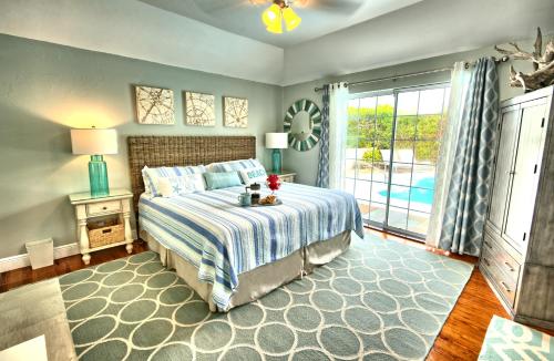 a bedroom with a bed and a large window at Beach Walk Cottage in Mount Pleasant