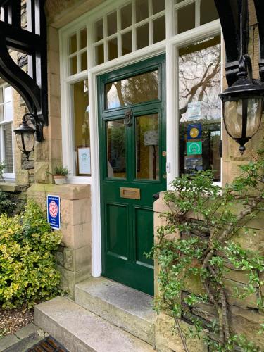 a green door on a house with a window at Ivythwaite Lodge Guest House in Windermere