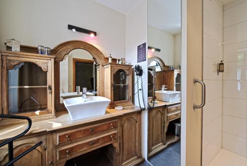 a bathroom with two sinks and two mirrors at Hotel Le Saint Hadelin in Celles