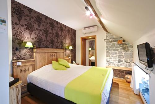 um quarto de hotel com uma cama e uma televisão em Hotel Le Saint Hadelin em Celles