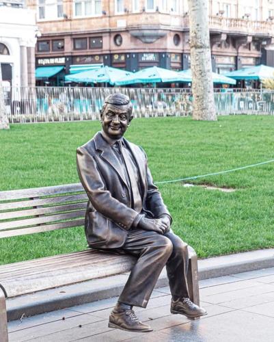 a statue of a man sitting on a bench at The Clermont London, Charing Cross in London