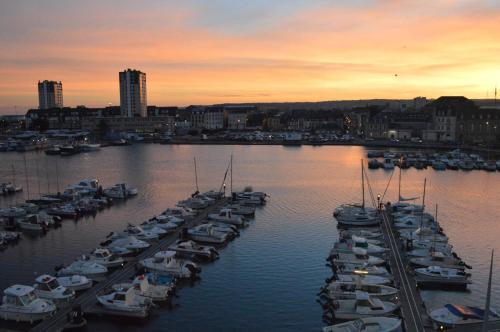 a group of boats docked in a marina at sunset at Ambassadeur Hotel - Cherbourg Port de Plaisance in Cherbourg en Cotentin