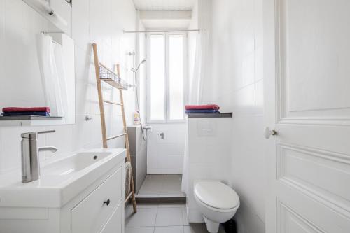a white bathroom with a toilet and a sink at Le Denfert, 40m2 avec vue in Grenoble