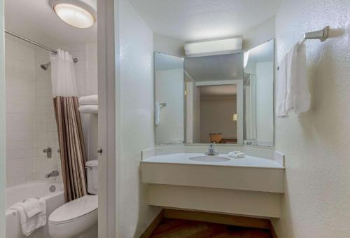 een badkamer met een wastafel, een toilet en een spiegel bij La Quinta Inn by Wyndham San Antonio I-35 N at Rittiman Rd in San Antonio