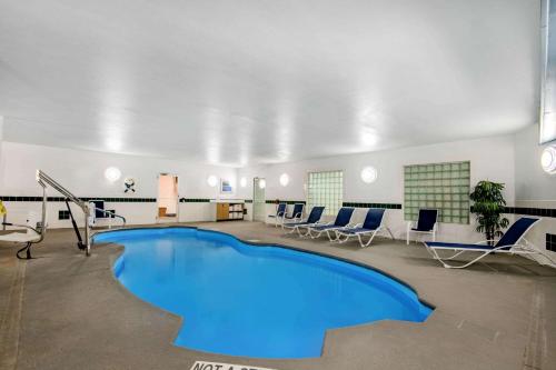 - une piscine dans une pièce avec des chaises et une table dans l'établissement La Quinta by Wyndham Dalhart, à Dalhart