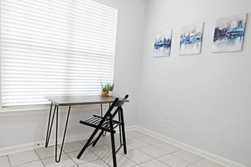 a table and a chair in front of a window at Dwell Proper 2 Bedroom Condo in Martinez