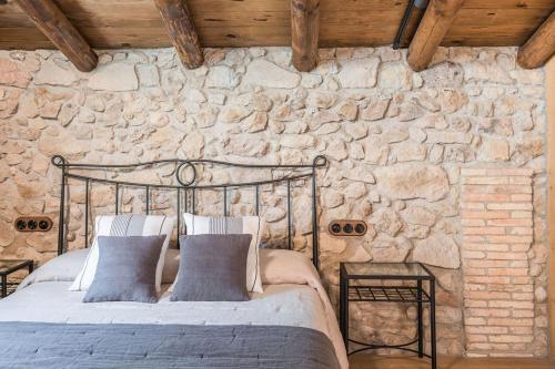 a bedroom with a bed in a stone wall at La Baumeta in San Mauricio