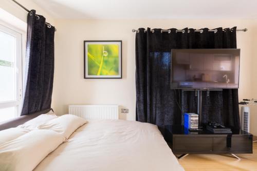 een slaapkamer met een bed en een flatscreen-tv bij Umbrella Properties Private Apartment Birmingham in Birmingham