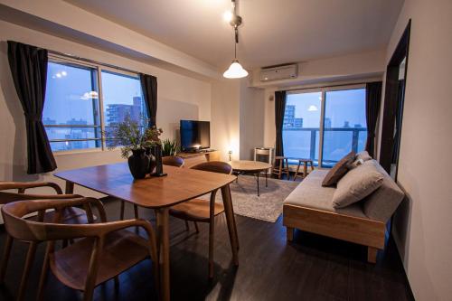 ein Wohnzimmer mit einem Tisch und einem Sofa in der Unterkunft Sun Court North 7 Ichibankan / Vacation STAY 7374 in Sapporo