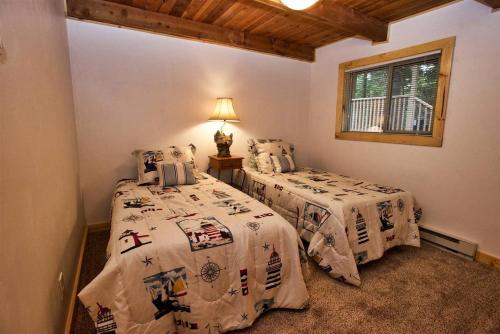 a bedroom with two beds and a window at Carlson Cabin by Casago McCall - Donerightmanagement in McCall
