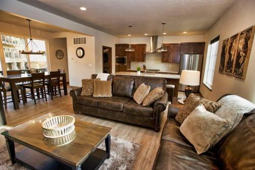 a living room with a leather couch and a table at Suite Retreat by Casago McCall - Donerightmanagement in McCall