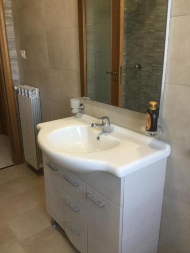 a bathroom with a white sink and a mirror at Maria's home in Pompei