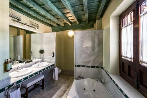y baño con 2 lavabos y bañera. en Hotel Casa Morisca, en Granada