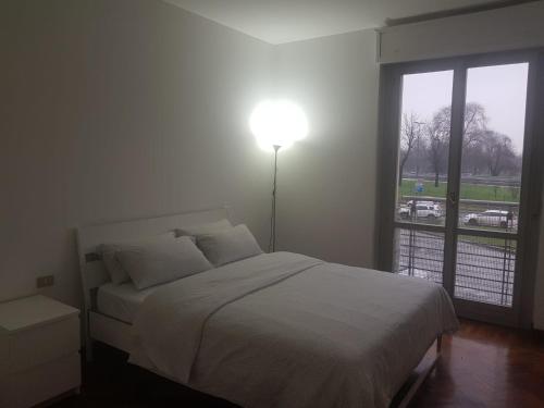 a bedroom with a bed and a large window at Sky Apartment in Milan
