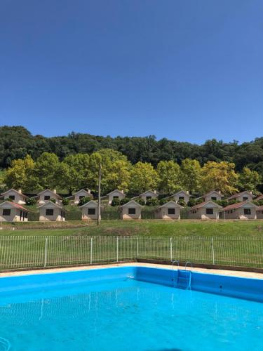 una piscina blu di fronte a alcune case di Pousada Parque das Pitangueiras a Flores da Cunha