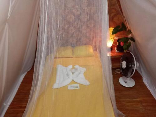 a wedding dress and shoes on a bed with a fan at SHUKRAN Apartelle in Siquijor