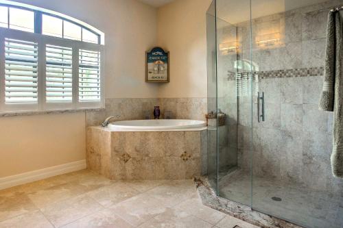 Das Bad ist mit einer Badewanne und einer Glasdusche ausgestattet. in der Unterkunft Elegant Waterfront Home on Cape Coral with Lanai! in Cape Coral