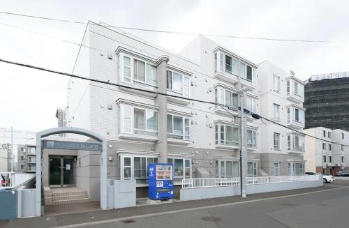 a white building on the corner of a street at Dynasty Palace Nijyuuyonken / Vacation STAY 7377 in Sapporo