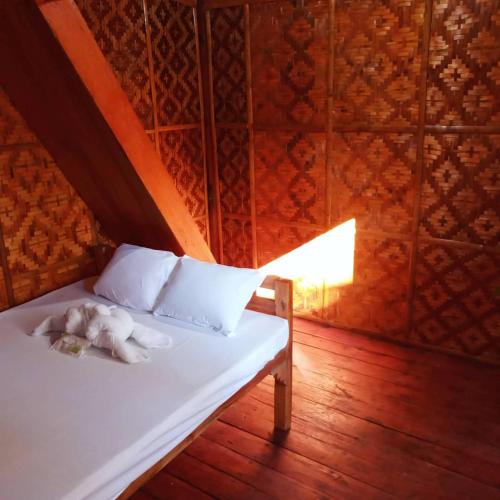 a white bed with a stuffed animal laying on it at SHUKRAN Apartelle in Siquijor
