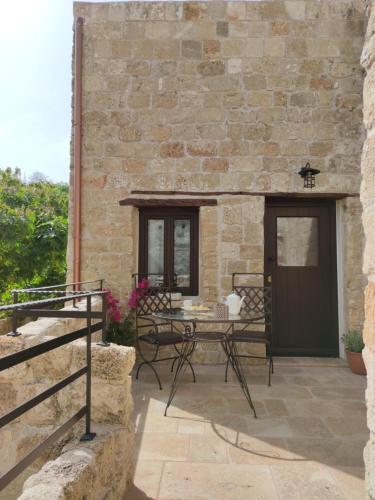 a patio with a table in front of a stone building at Porolithos Boutique Hotel in Rhodes Town