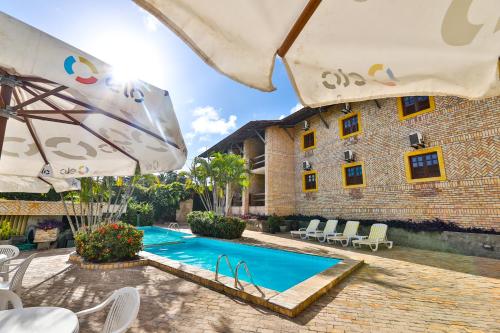 a resort with a swimming pool in front of a building at Pousada da Ladeira in Pipa