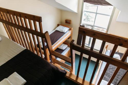 a bedroom with a bed and two wooden staircases at HI Lake Louise Alpine Centre - Hostel in Lake Louise